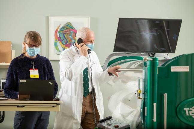 Doctors overseeing a patient getting treatment in a hyperbaric chamber